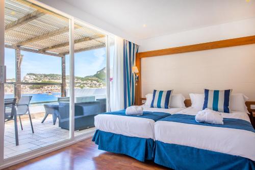 a bedroom with a large bed and a balcony at Los Geranios in Port de Soller