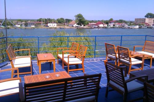 una terraza con mesas y sillas y vistas al agua en Marina House, en Sulina