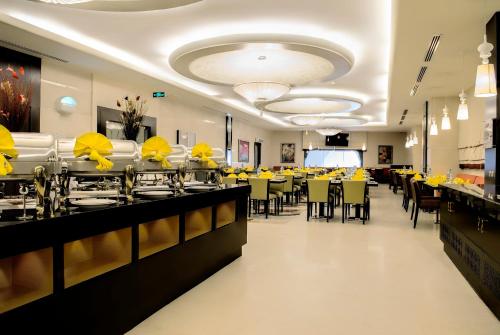 a dining room with yellow tables and chairs at Al Ghufran Safwah Hotel Makkah in Makkah