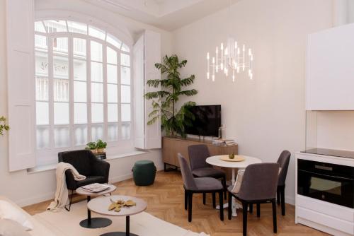 a living room with a table and chairs and a tv at Plaza Mina Suites - Adults Recommended by Luxury Suites Cadiz in Cádiz