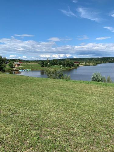 a view of a river from a field of grass at Willa Różowy Domek in Rakowice Małe