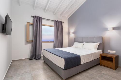 a bedroom with a bed and a large window at Anasa Corfu in Benitses