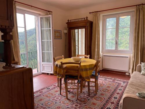 a dining room with a table and some windows at Castillon - Maritime Alpes in Castillon