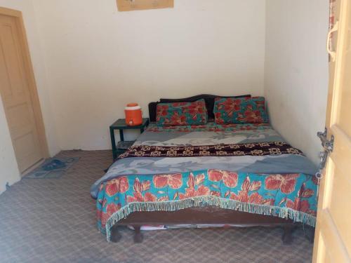 um pequeno quarto com uma cama num quarto em Zahoor Hotel And Restaurant em Barāniā