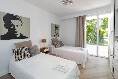 a bedroom with two beds and a window at Villa Flamingos Marbella in Marbella