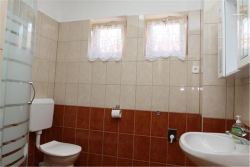 a bathroom with a toilet and a sink at Erika Apartmanházak in Hévíz