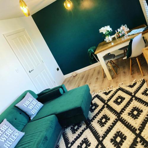 a living room with a green couch and a table at Bay Retreat Apartment The Bay Holiday Village Filey Homesweetholidayhomes in Filey