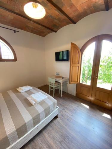 a bedroom with a bed and a table and a window at La Magnolia in Greve in Chianti