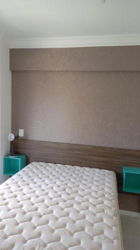 Cama en habitación con colchón blanco en Atalanta 201A, en Bombinhas