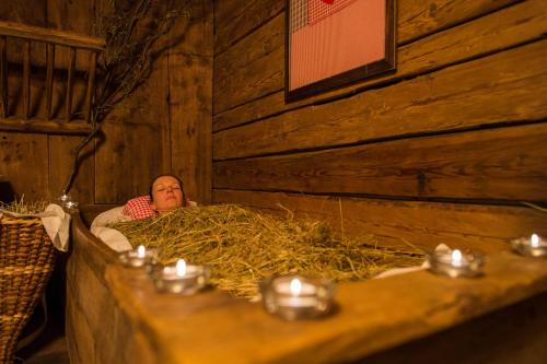 a man laying in a pile of hay in a barn at Hotel Mühlenerhof in Campo Tures