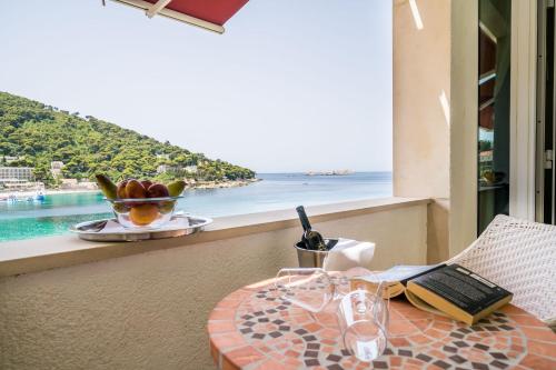 a table on a balcony with a view of the ocean at Boutique & Beach Hotel Villa Wolff in Dubrovnik