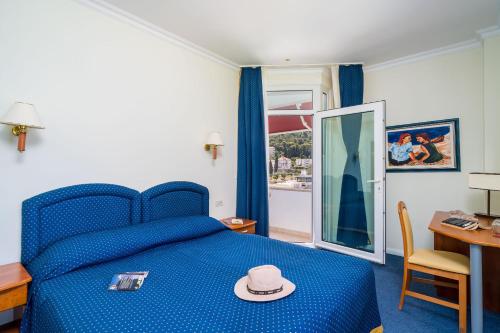 a bedroom with a blue bed with a hat on it at Boutique & Beach Hotel Villa Wolff in Dubrovnik