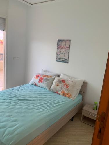a bedroom with a bed with blue sheets and pillows at A 5 minutes à pied de la plage un bel appartement à saisir in Sidi Rahal