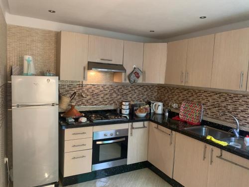 a kitchen with a refrigerator and a stove top oven at A 5 minutes à pied de la plage un bel appartement à saisir in Sidi Rahal