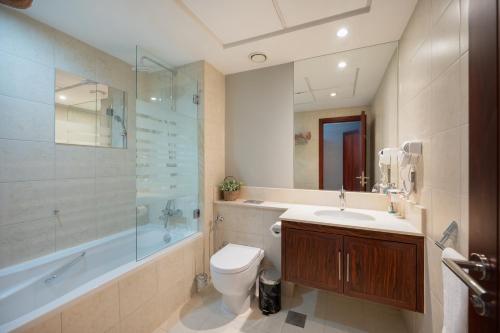 ein Bad mit einem WC, einem Waschbecken und einer Dusche in der Unterkunft Burj Residence by Radiance Vacation Stays in Dubai