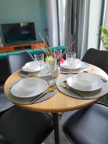 a wooden table with plates and glasses on it at atPUUTA in Saulkrasti