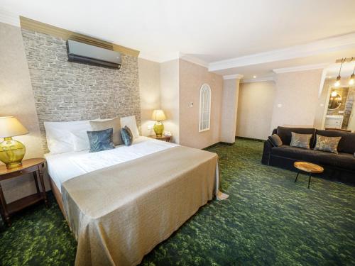 a hotel room with a large bed and a couch at Platan Udvarhaz in Tata
