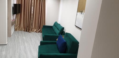 a green couch with a blue pillow in a room at AFRODITE SUITES in Sarandë