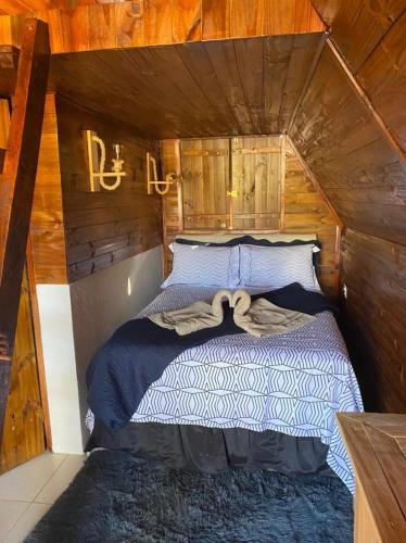 a bedroom with a bed in a wooden cabin at Pousada Lago Azul in Delfinópolis