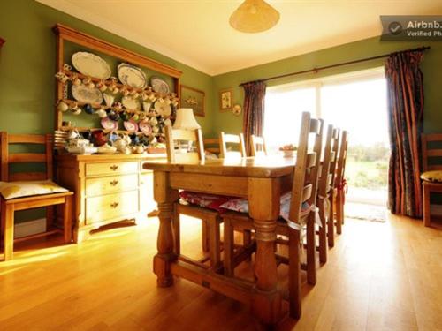 a dining room with a wooden table and chairs at Swallows Rest in Weymouth