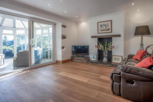 a living room with a couch and a television at Sea View - 2 Bedroom Cottage - Wisemans Bridge - Saundersfoot in Stepaside