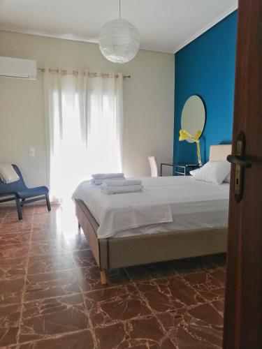 a bedroom with a large bed and a blue wall at Cosy Retro Apartment in Zakynthos Town