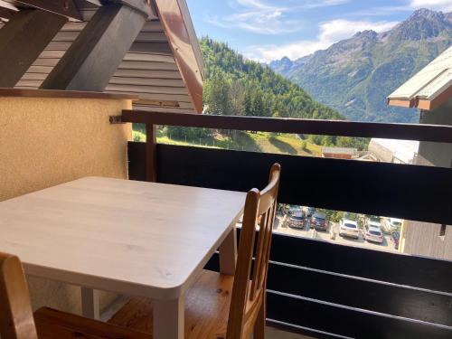 a white table and chairs on a balcony with a view at Les pistes, studio 4 personnes au pied du télécabine in Oz