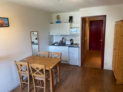 a kitchen with a table and chairs in a room at Les pistes, studio 4 personnes au pied du télécabine in Oz