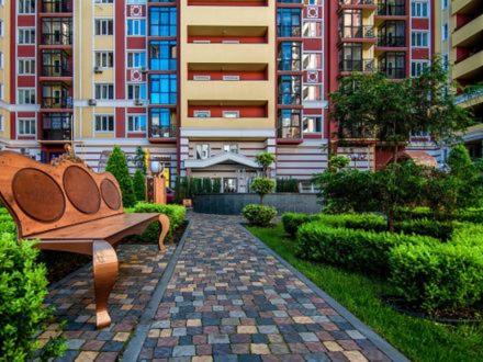a bench sitting in the middle of a courtyard with tall buildings at ЖК Версаль парк in Irpin'