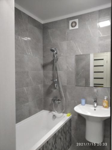 a bathroom with a bath tub and a sink at ЖК Версаль парк in Irpin'