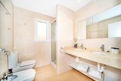 a bathroom with a toilet and a sink and a mirror at Residence El Paraiso in Sa Ràpita
