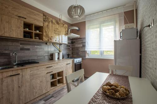 a kitchen with a table and a white refrigerator at Center Home Apartman in Orosháza