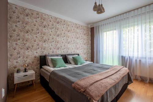 una camera da letto con un grande letto con cuscini verdi di Center Home Apartman a Orosháza