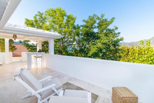 a patio with white chairs on a white wall at Giritimu B'yaz in Selimiye