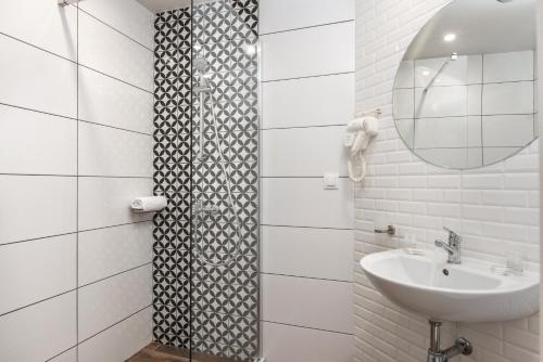 een witte badkamer met een wastafel en een spiegel bij Casa Paradiso Beach Residence in Ahtopol