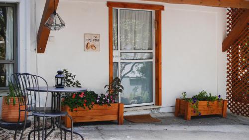 a patio with a table and chairs and a window at בין האלונים in H̱arashim
