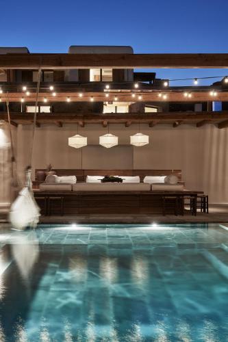 a large swimming pool with blue water in a room at Nomad Mykonos - Small Luxury Hotels of the World in Kalo Livadi
