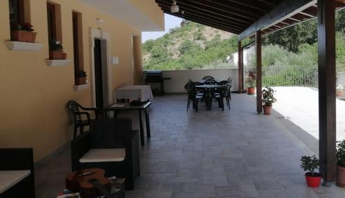 a patio with tables and chairs in a house at Agriturismo CuoreLieto del Cilento in Corleto Monforte