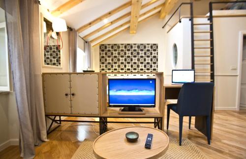 een woonkamer met een televisie en een bureau met een stoel bij Borelli Palace & Borelli Blue in Zadar