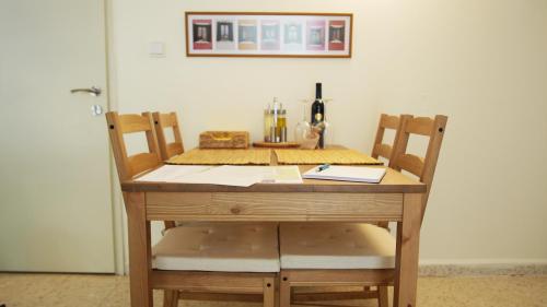 a wooden table with two chairs and a bottle of wine at בין האלונים in H̱arashim