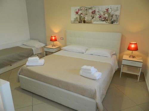 1 dormitorio con 2 camas y 2 mesas con lámparas en A Casa di Anna - Locazione Turistica -, en Matera