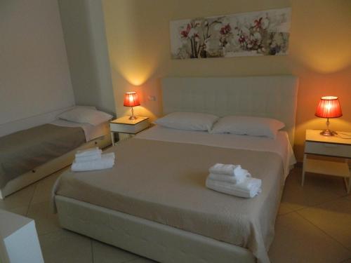 two beds in a room with two lamps on tables at A Casa di Anna - Locazione Turistica - in Matera