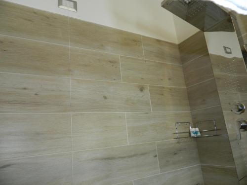 a bathroom with a shower with a large wooden wall at A Casa di Anna - Locazione Turistica - in Matera