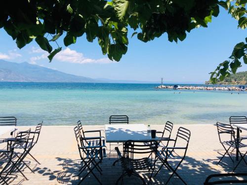 een tafel en stoelen op een strand met uitzicht op de oceaan bij Seaside studio for 3 people - Alykes beach in Dhimínion