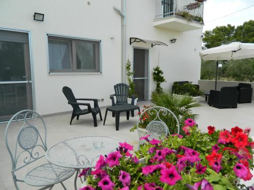 a patio with a table and chairs and flowers at A Casa di Anna - Locazione Turistica - in Matera