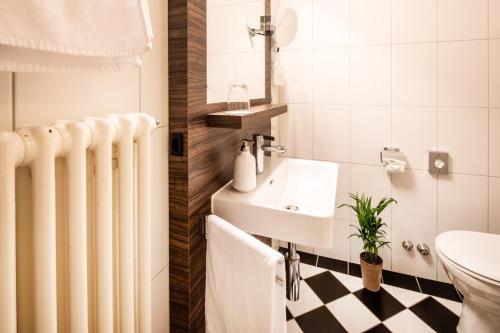 a bathroom with a radiator and a sink and a toilet at Hotel Roter Turm in Solothurn