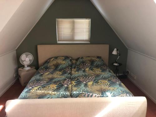 1 dormitorio con 1 cama con pared verde en B&B aan de Hoofdkade, en Ter Apel