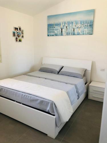 a white bedroom with a large white bed in it at Villa Melissa in Tertenìa