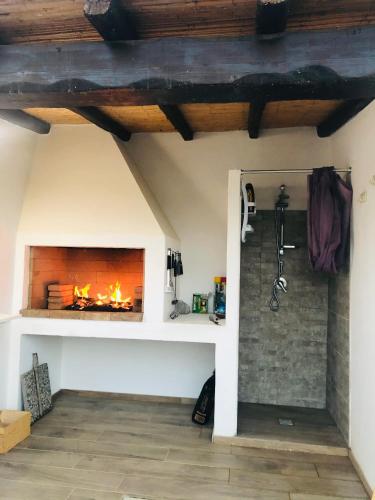 a living room with a fireplace and a shower at Villa Melissa in Tertenìa