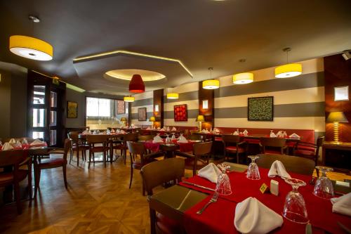 a restaurant with tables and chairs with red table cloth at Hotel Atlantic Agdal in Rabat